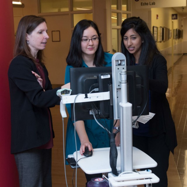 H. Barrett Fromme, MD, MHPE, looking at a computer with Kathy Harold, MD, and Geetha Sridharan, MD