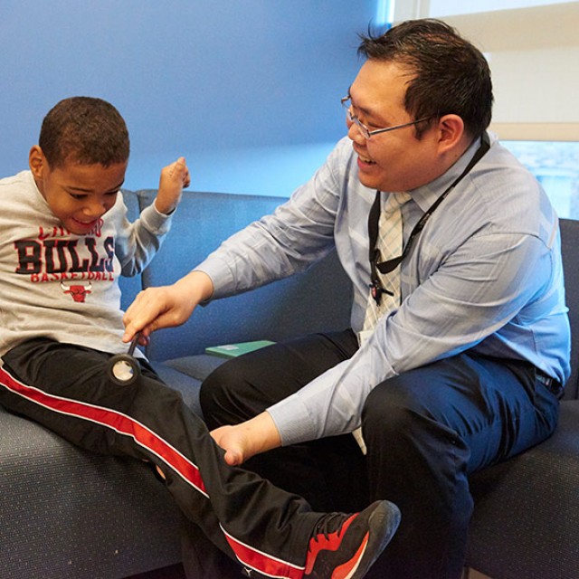 Chalongchai Phitsanuwong, MD checks Patient William Sterling&#039;s reflexes