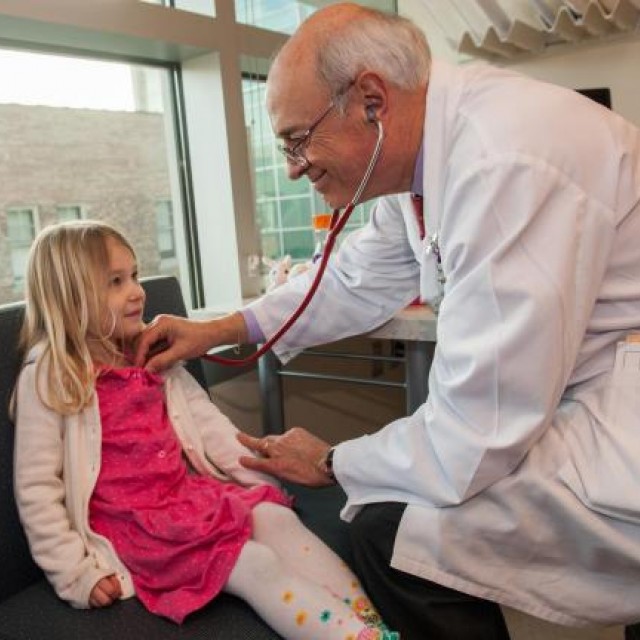Doctor checks young patient with stethoscope