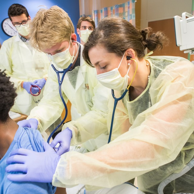 Medical students check patient with a stethoscope 