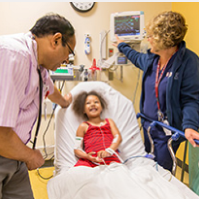 Patient laughs with two medical providers 